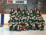 Malmont Farms Team in green jerseys standing on ice in front of home bench