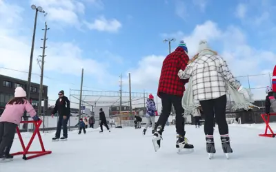 crowd of people skating on outdoor rink in Joe Fowler ball diamond
