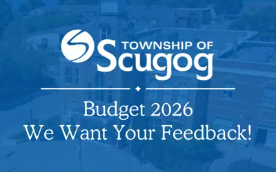 blue-tinted drone shot of Municipal Office with overlay of white Scugog logo and wording reading 'Budget 2026, we want your feedback!'
