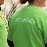 back of green shirt with the word volunteer