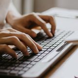 hands typing at a laptop keyboard